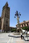 Perpective sur la Giralda depuis la fontaine sur la place del Triunfo, Séville, Espagne.