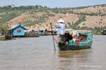 Marchand flottant arrivant dans un village sur pilotis, Tonlé Sap, Cambodge.