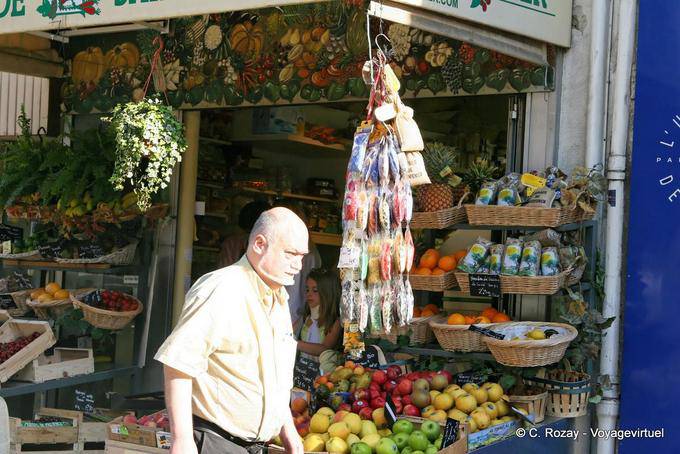 Passant devant étal de marchand de fruits et légumes, Avignon, Provence, France