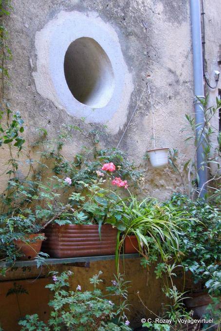 Ramatuelle, oeil de boeuf dans le mur et fleurissement, Provence, France