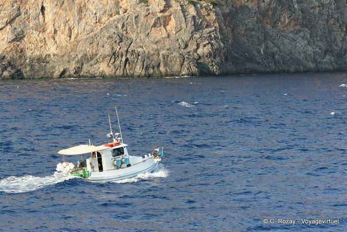 Bateau de pêche naviguant le long d'une falaise, Hora Sfakion - Crète, Grèce
