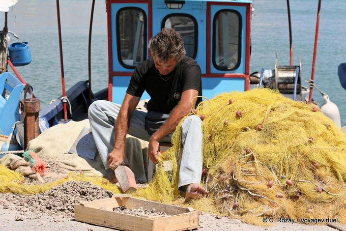 Martelage des coquillages pris dans le filet, port d'Iraklio (Heraklion) - Crète, Grèce