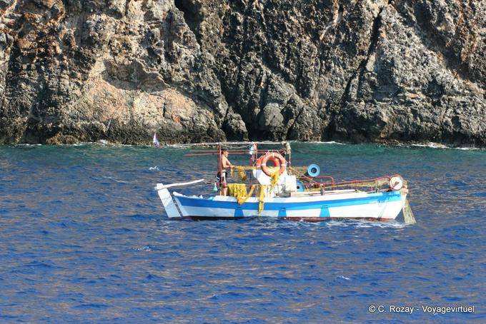 Pêcheur dans son bateau au bord des falaises vers Sougia - Crète, Grèce