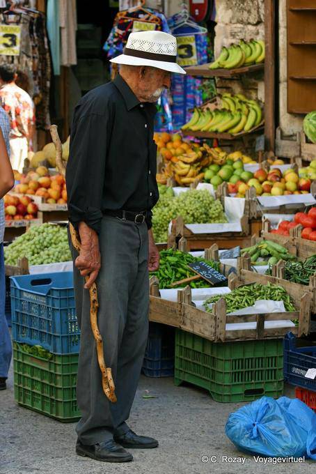 Crètois à la canne devant un étal de fruits et légumes, Réthymnon - Crète, Grèce