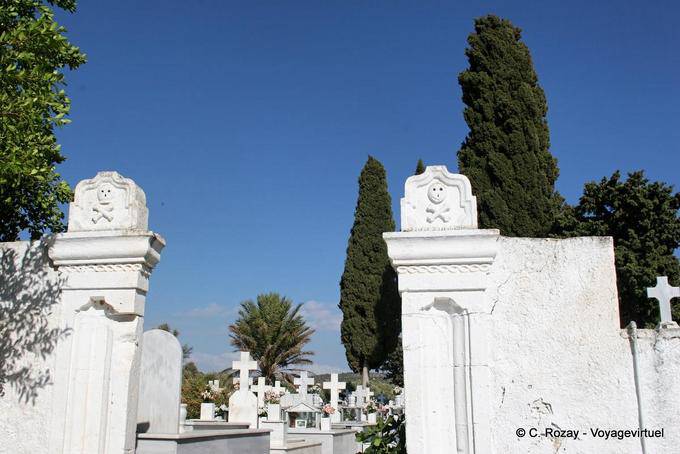 Têtes de mort à l'italienne sur entrée du cimetière, Vori - Crète, Grèce