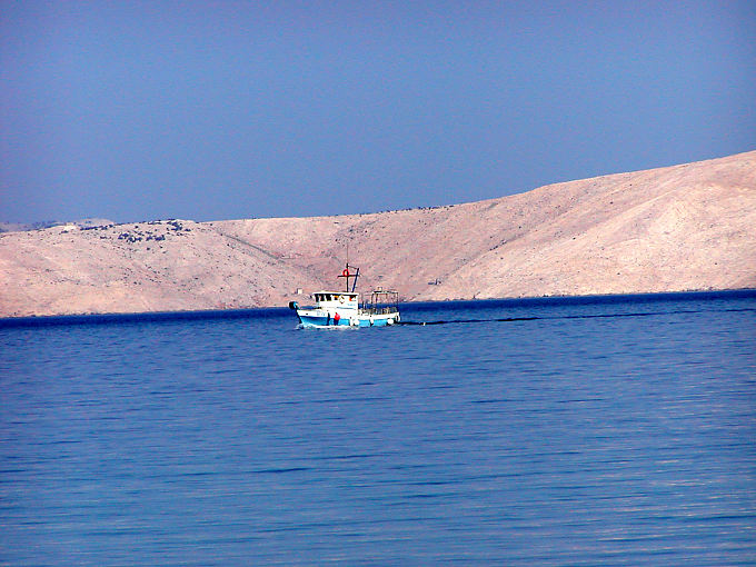 Bateau de pêche passant devant l'île Goli Otok - Croatie