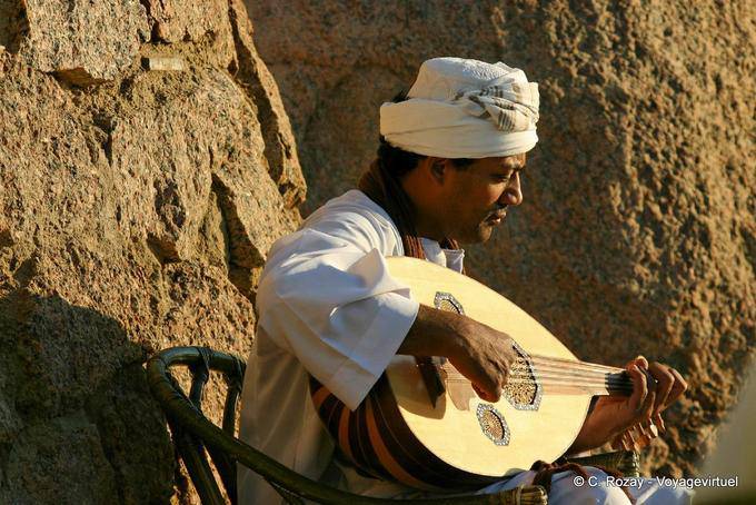 Musicien jouant du 3ood, luth oriental, devant le Old Cataract, Assouan - Égypte