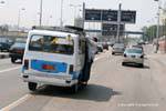 Homme accroché à l'extérieur du taxi surchargé, Le Caire, Egypte.
