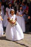 Fillette en robe blanche avec une poupée, procession à Tolède, Espagne.