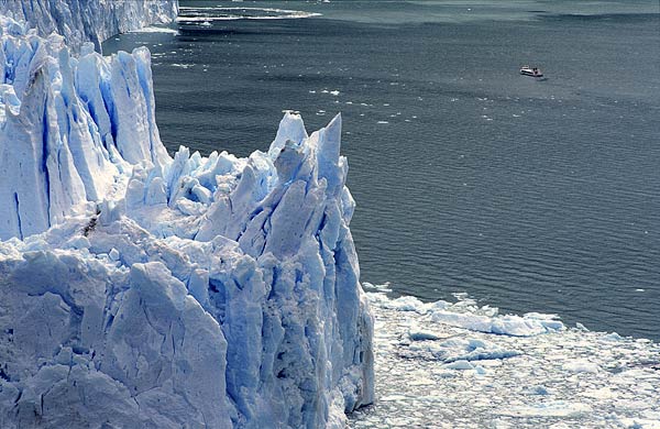Falaises de glace sur le front du glacier Perito Moreno s'avance sur le lago Argentino. Argentine
Quelques bateaux y emmènent des touristes, mais restent prudemment à distance car des séracs s'effondrent régulièrement dans un bruit de tonnerre. Patagonie, décembre 2002 
Mots-clés: glaciers paysages Argentine Amériques
