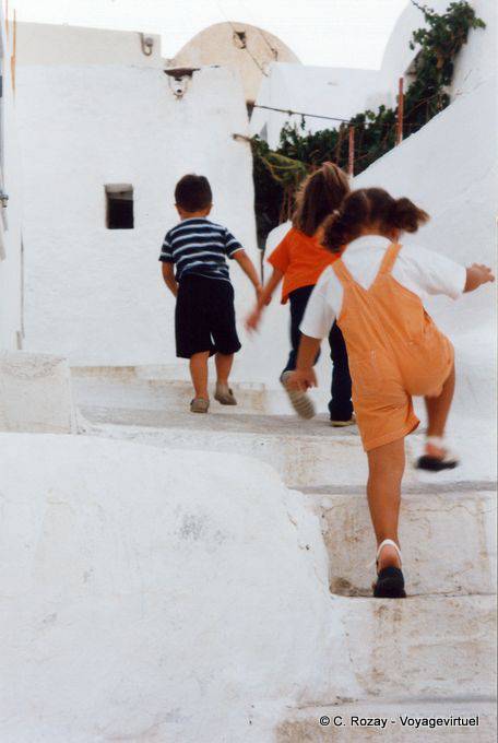 Enfants qui courent dans les marches de Chora, Anafi - Grèce