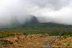 Chemin de terre et nuages sur la Conor Pass, Dingle, Irlande.