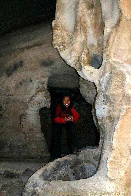 Sourire d'enfant dans une salle à manger troglodyte, équipée d'un bassin, Little Pétra - Jordanie