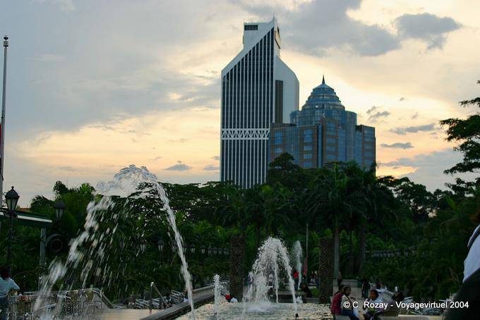 Soleil couchant et jets d'eau devant le Menara Olympia et Maybank, Kuala Lumpur - Malaisie