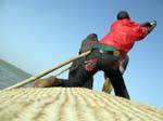 Efforts avec perches pour sortir la pinasse du sable, Mali.