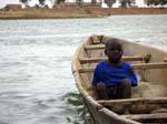 Gamin dans une pirogue traditionnelle monoxyle, Mali.