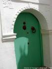 Une porte verte avec une main de Fatma, Asilah, Maroc.
