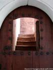 Ouverture dans une porte de bois et escalier, Médersa Ben Youssef, Marrakech, Maroc.