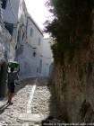 Ruelle pavée de galets et enfant portant le linge sur sa tête, Chefchaouen, Maroc.