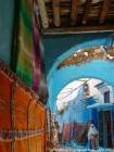 Tapis multicolores dans un passage couvert du souk, Chefchaouen, Maroc.
