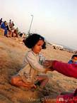 Une petite fille jouant sur la plage Tagharte, Essaouira, Maroc.