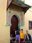 Sur le pas de la porte décorée, Meknès, Maroc.