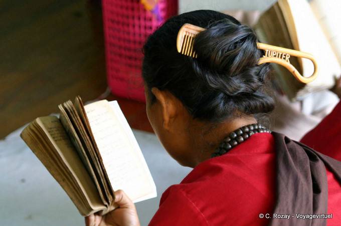 Birmane lisant avec un peigne dans les cheveux, Mont Popa - Myanmar (Birmanie)