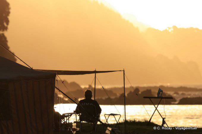 Campeur au coucher du soleil, Maraehako Bay, East Cape - Nouvelle-Zélande
