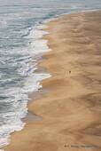 Le pêcheur seul sur l'immense plage au nord de Nazaré, Portugal.