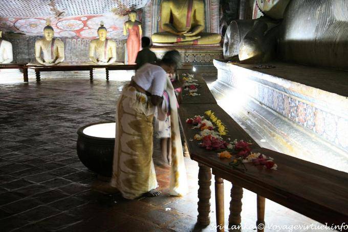 Offrandes et prière devant le bouddha parinirvana,grotte du Divin Roi, Dambulla - Ceylan Sri Lanka