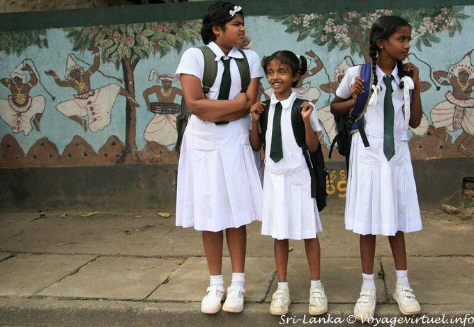 Trio d'écolières en uniforme devant une fresque murale, Kandy - Ceylan Sri Lanka