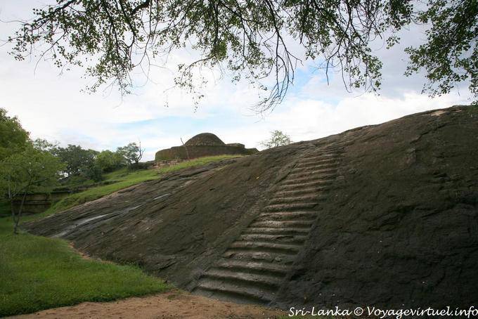 Accès, par escaliers creusés dans la roche, au stupa en face de la vatadagaya, le plus ancien bâtiment de Medirigiriya, Medirigiriya - Ceylan Sri Lanka