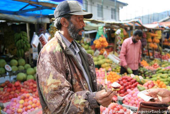 Proposition de goûter un ramboutan, sorte de litchi, marché de Nuwara Eliya - Ceylan Sri Lanka