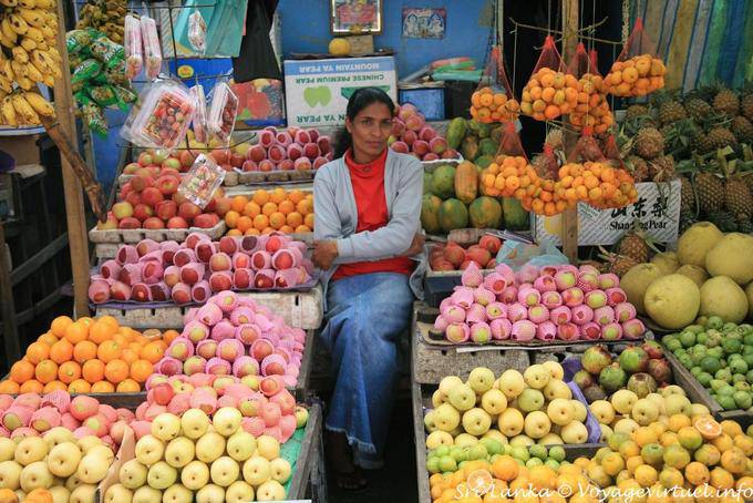 Vendeuse entre pommes et oranges au marché, Nuwara Eliya - Ceylan Sri Lanka