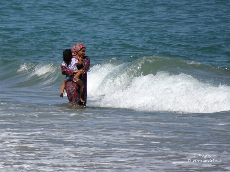 Baignade d'une omanaise avec sa fille dans les vagues de la plage de Yiti. Environs De Muscat