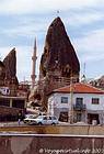 Minaret, habitat troglodytique et maison classique, Cappadoce, Turquie.