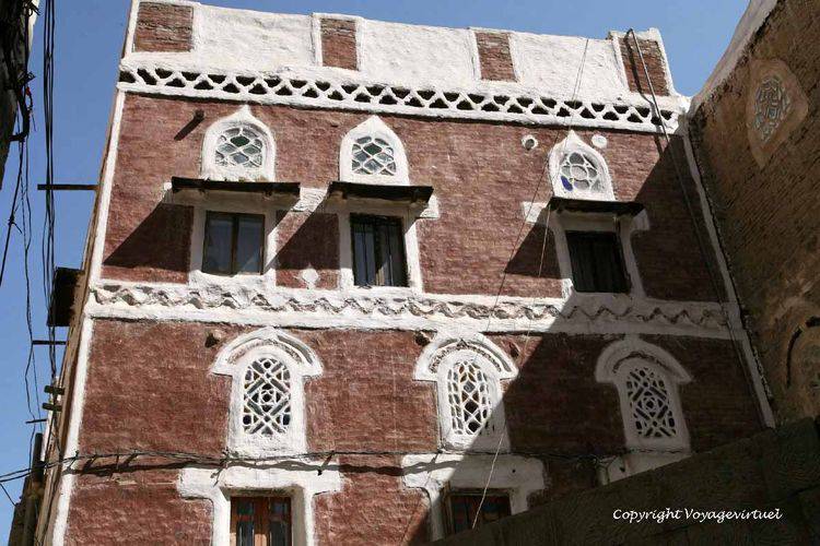 Façade rouge aux vitraux tempérés de claustras de plâtre
Mots-clés: Sanaa